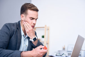 Man taking medicine for TMJ pain