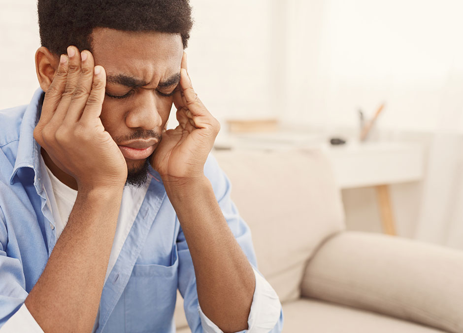 African-american man suffering from headache at home